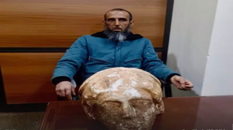 A citizen in Shahat delivers the head of an archaeological statue to Antiquities Control